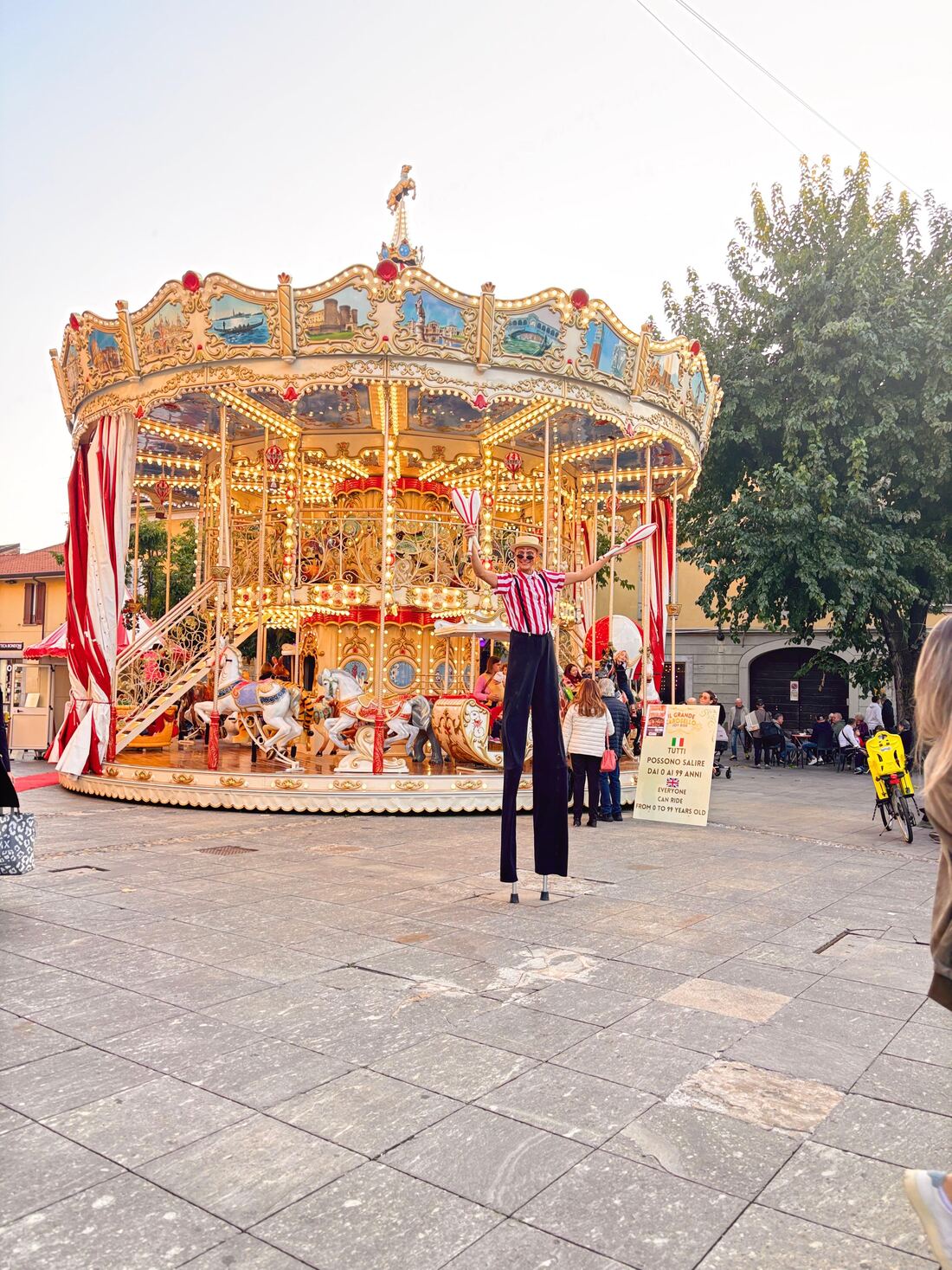 Artista sui trampoli davanti a Il Grande Carosello Joy Ride
